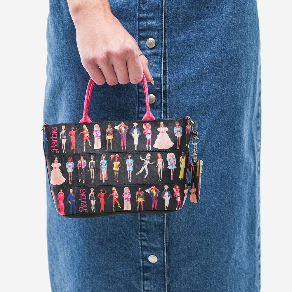 The Barbie Through The Eras Petite Tote being held by a model