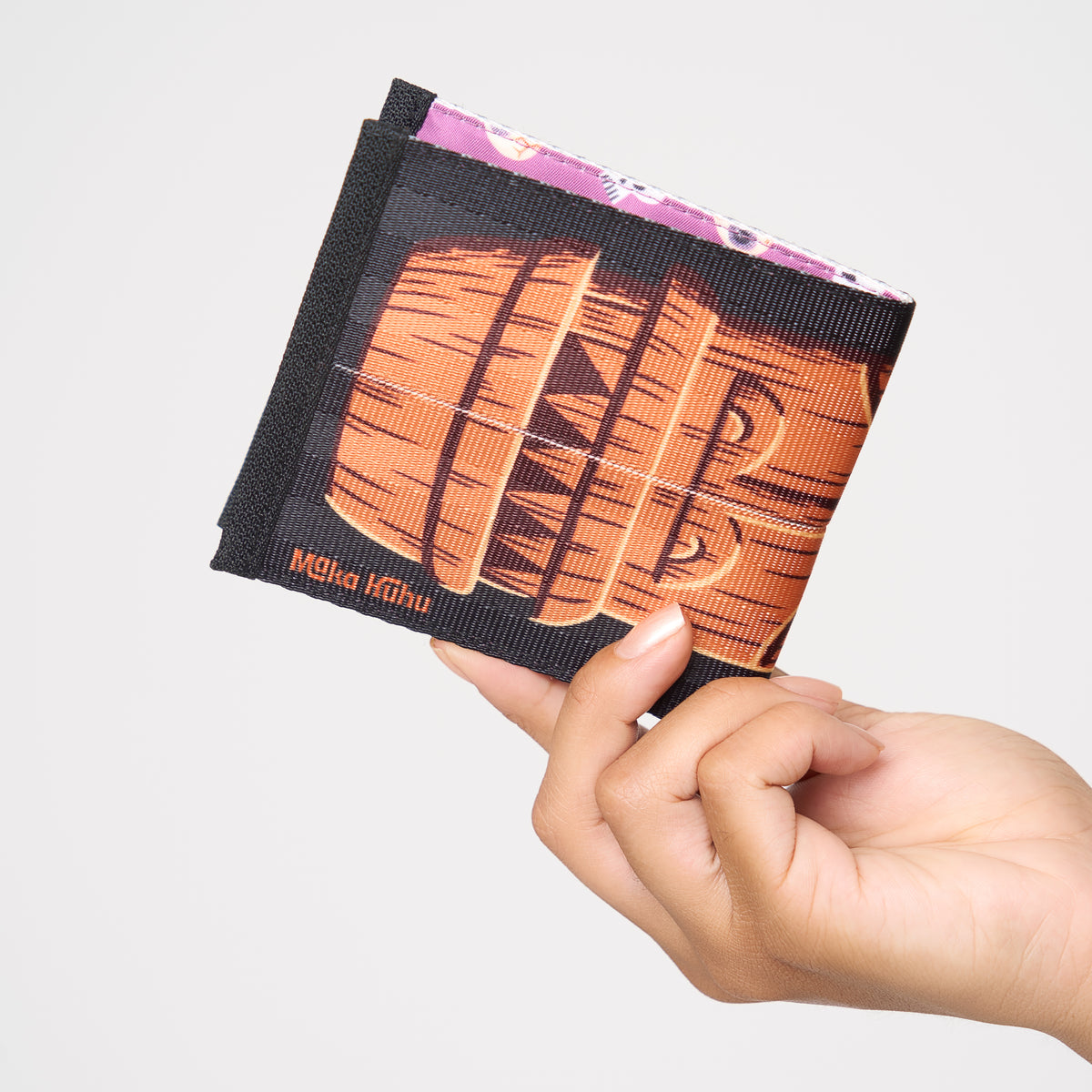 Model holding closed billfold Shag Maka Huhu