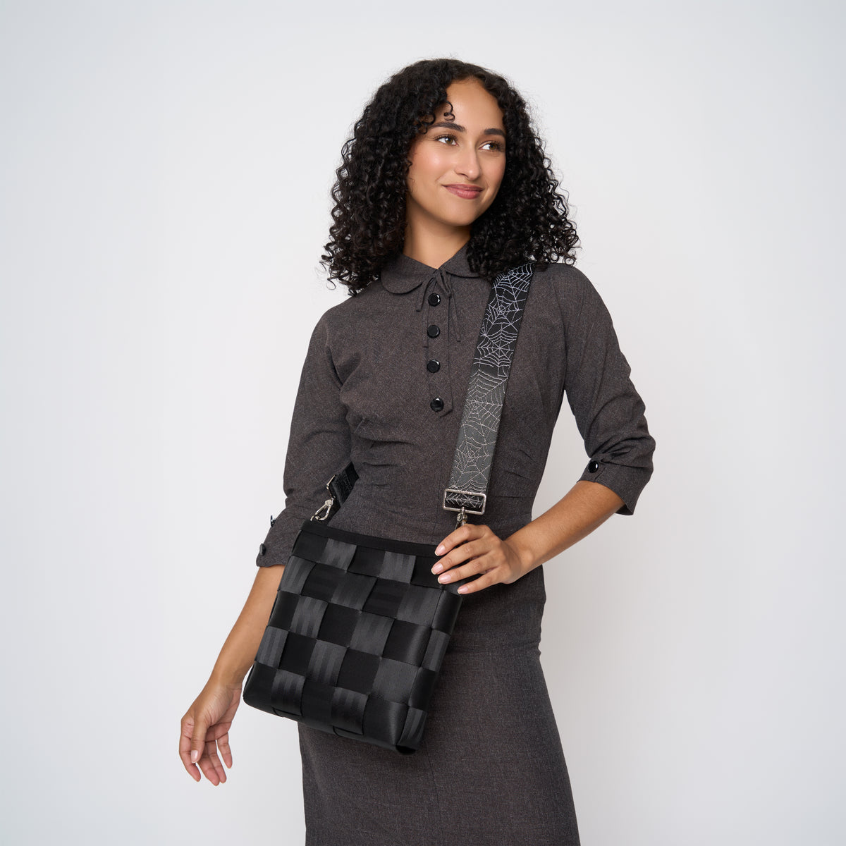 A model wearing a Black Widow 5 Panel Click N Carry with a bag