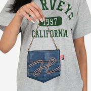 Coin Purse with chain in denim with an embroidered front design in a models hand