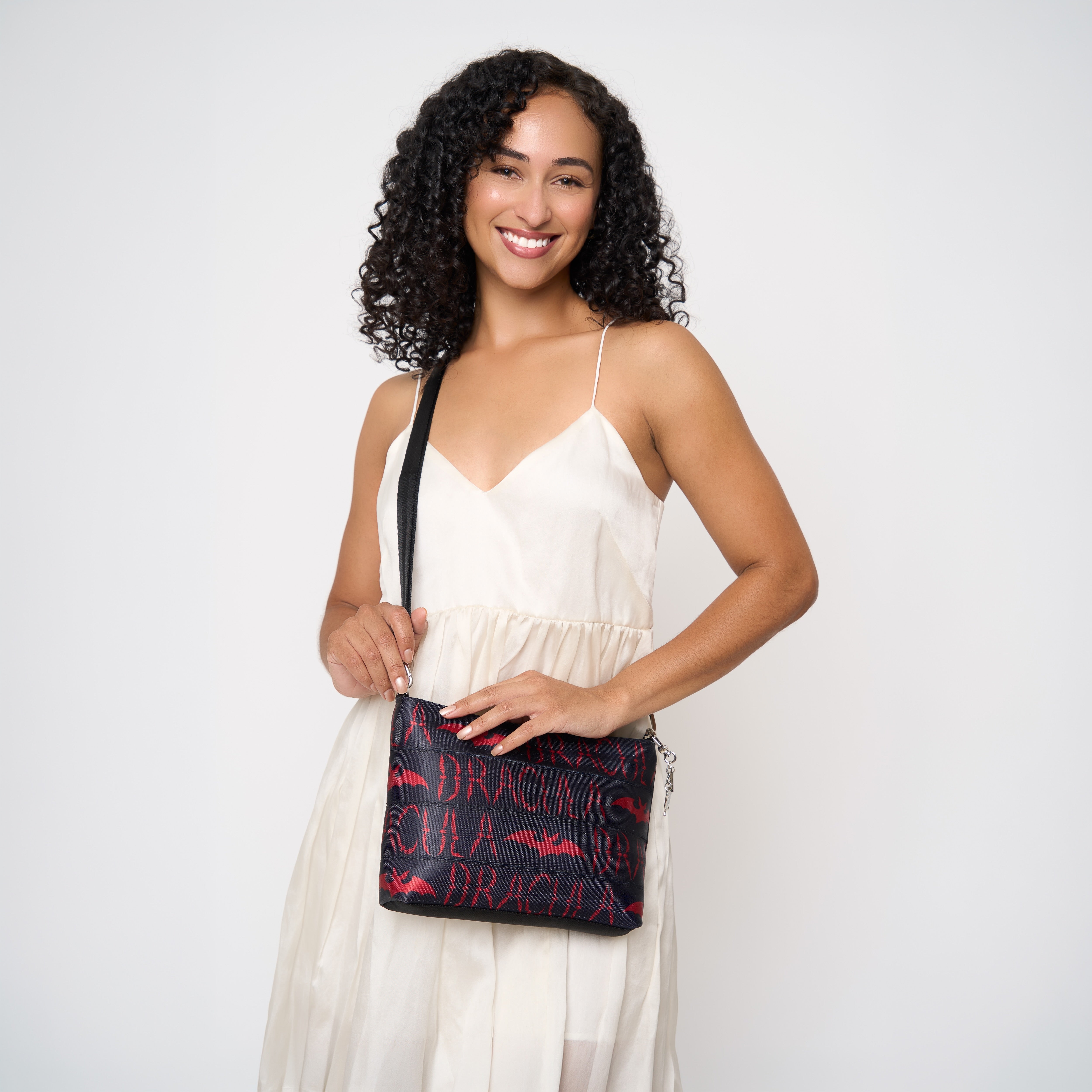 Model wearing black clutch using adjustable black strap