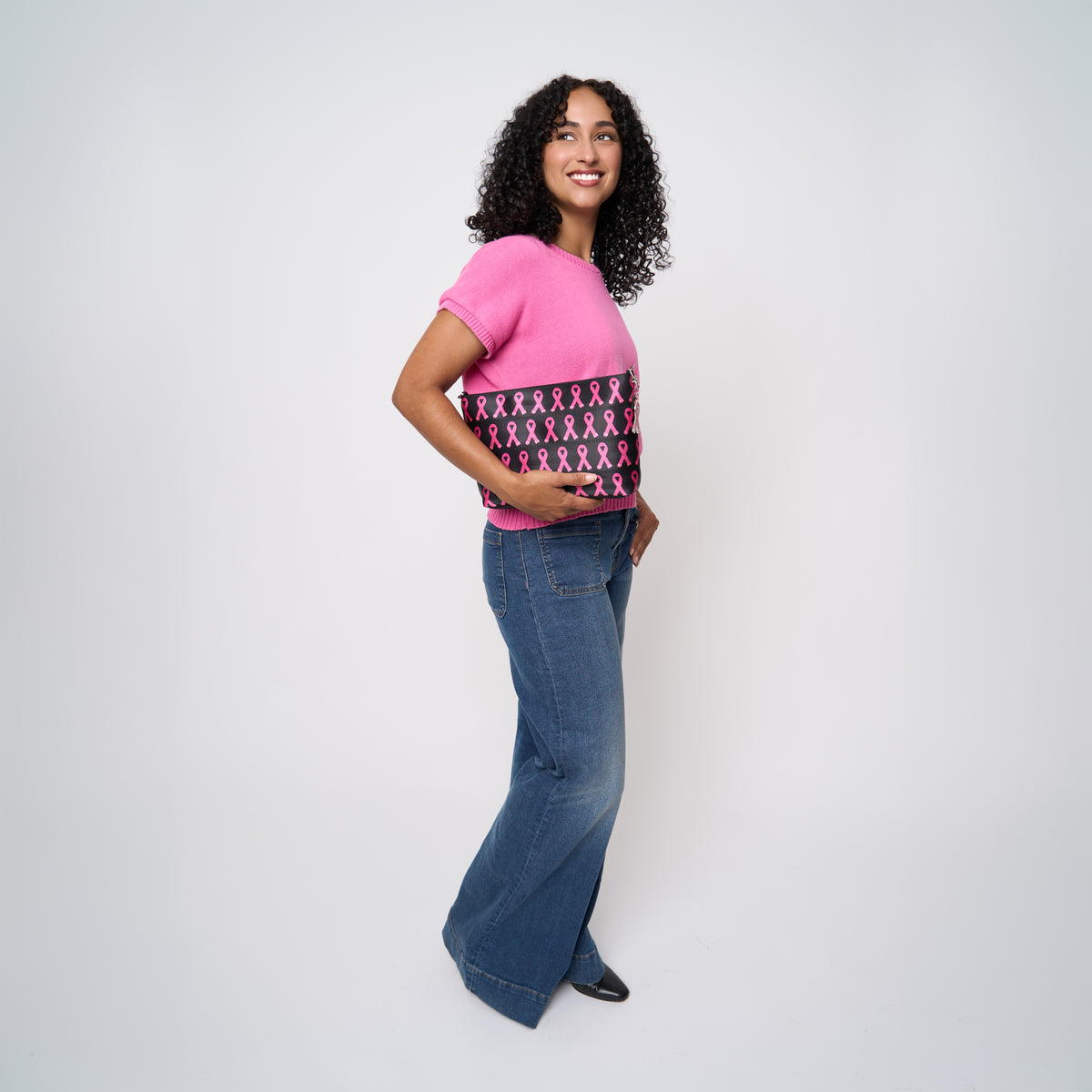A model wearing The Pink Agenda Pink Ribbon Medium Convertible Clutch
