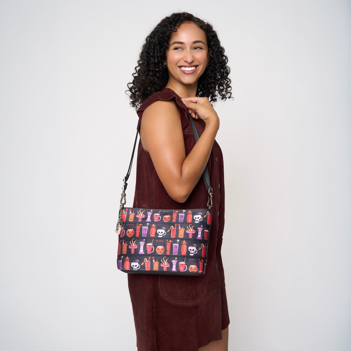 Model using extendible shoulder strap to wear Medium Convertible Clutch Shag Spooky Tiki Cocktail