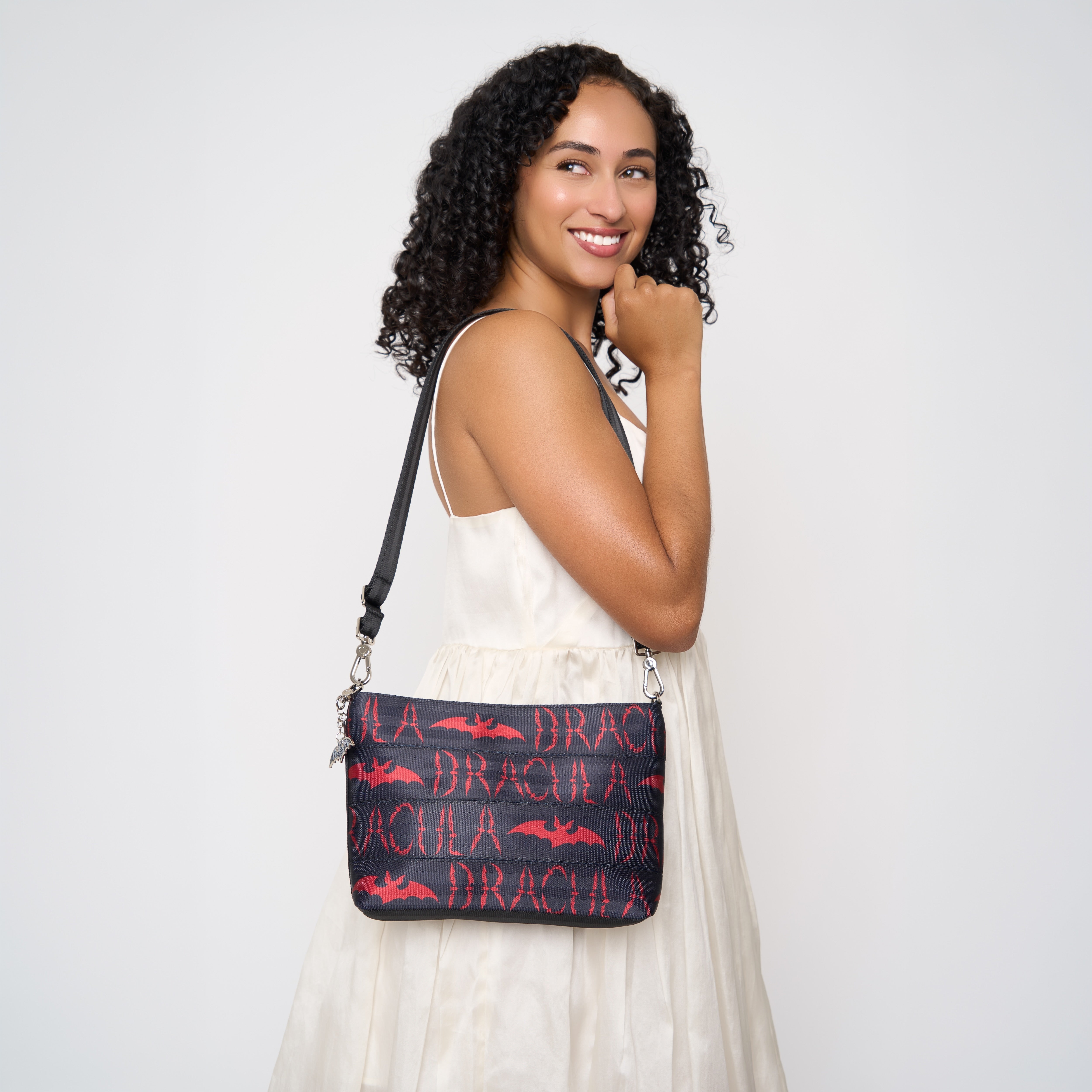 Model wearing black clutch with black shoulder strap