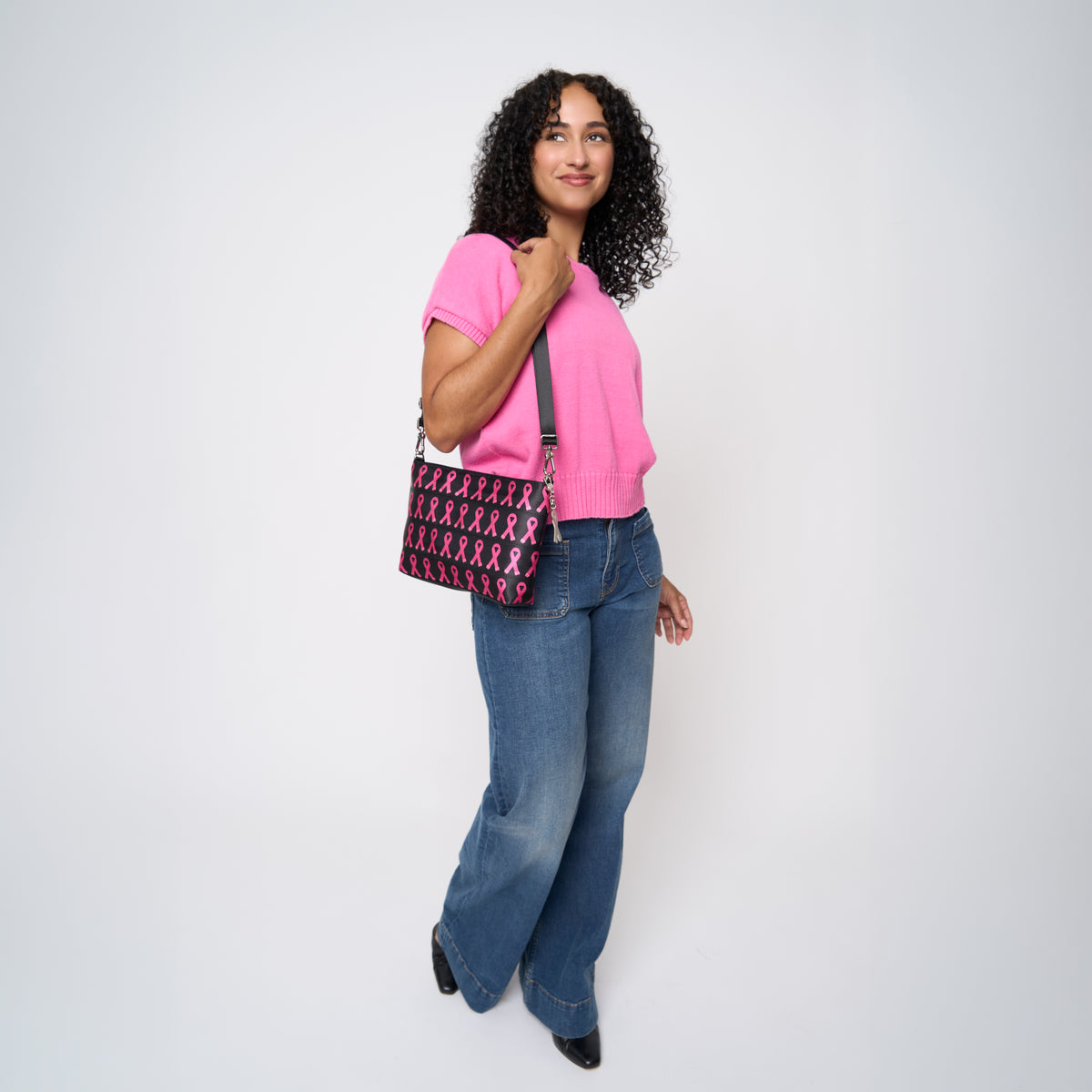 A model wearing The Pink Agenda Pink Ribbon Medium Convertible Clutch