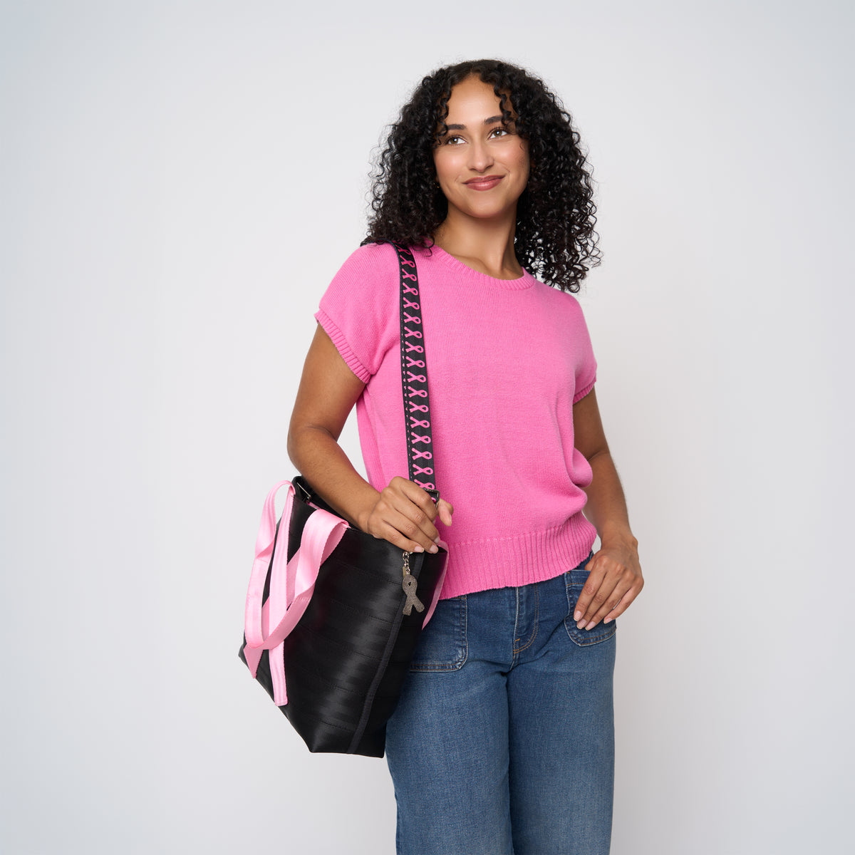A model wearing The Pink Agenda Pink Ribbon Medium Streamline Tote