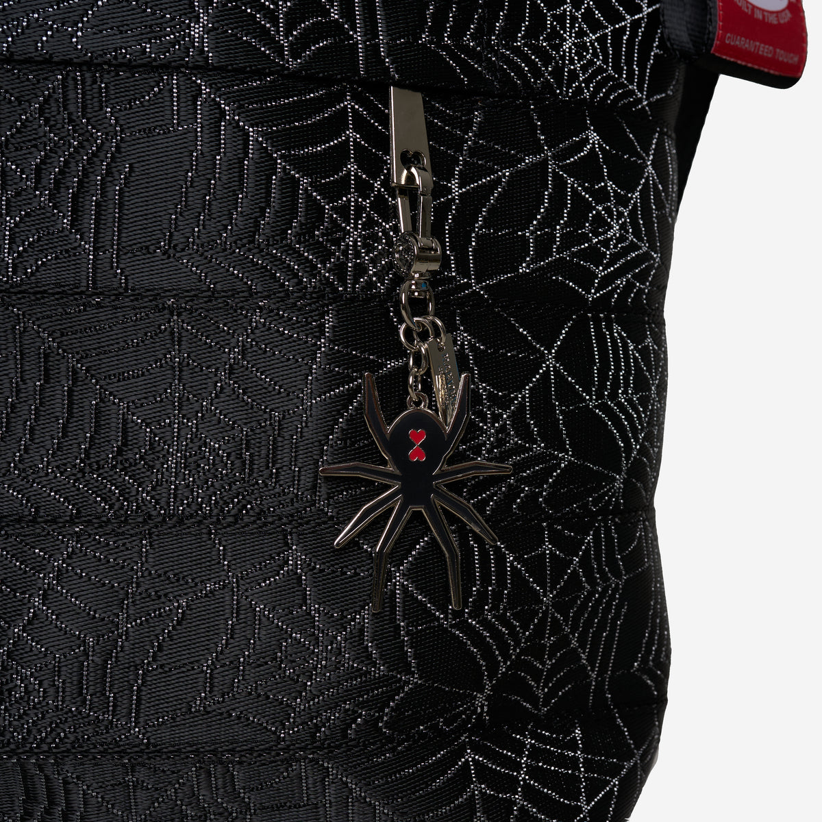 The charm detail of a Black Widow Medium Streamline Tote