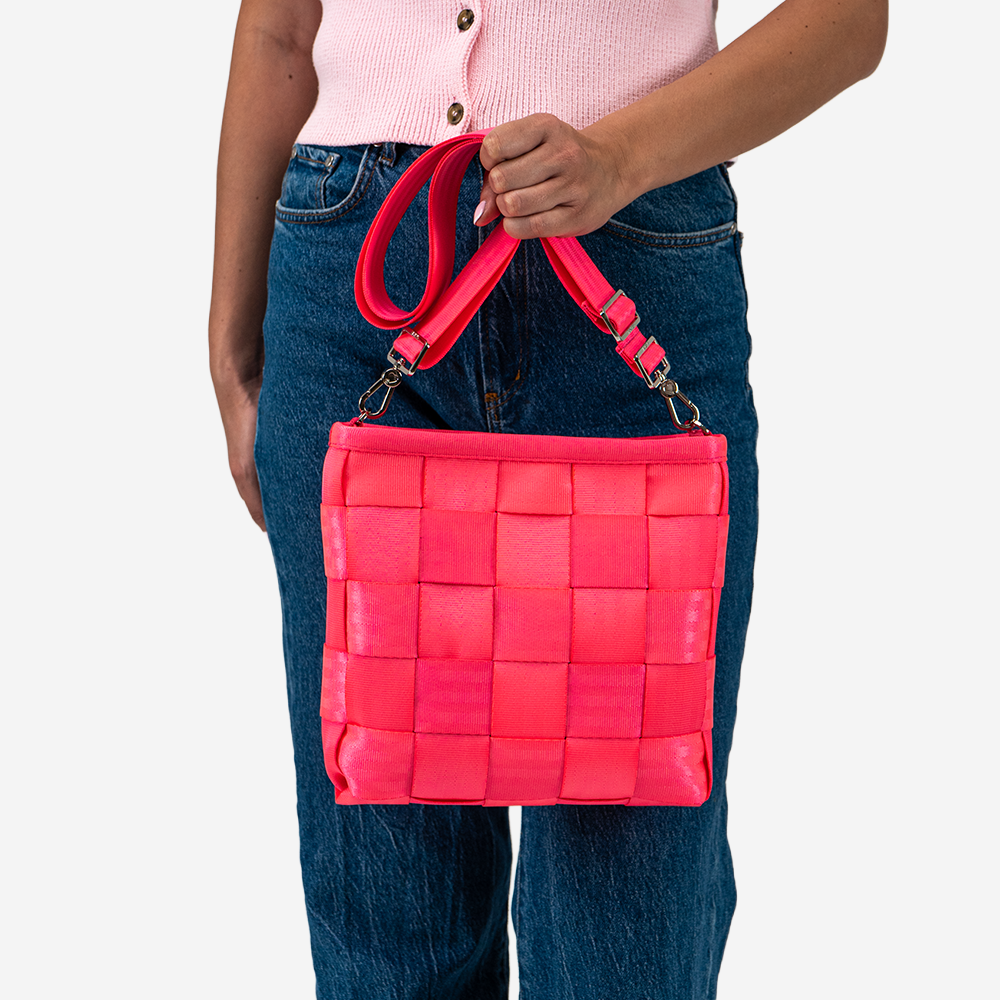 The Mini Messenger in Dragonfruit being held by a model