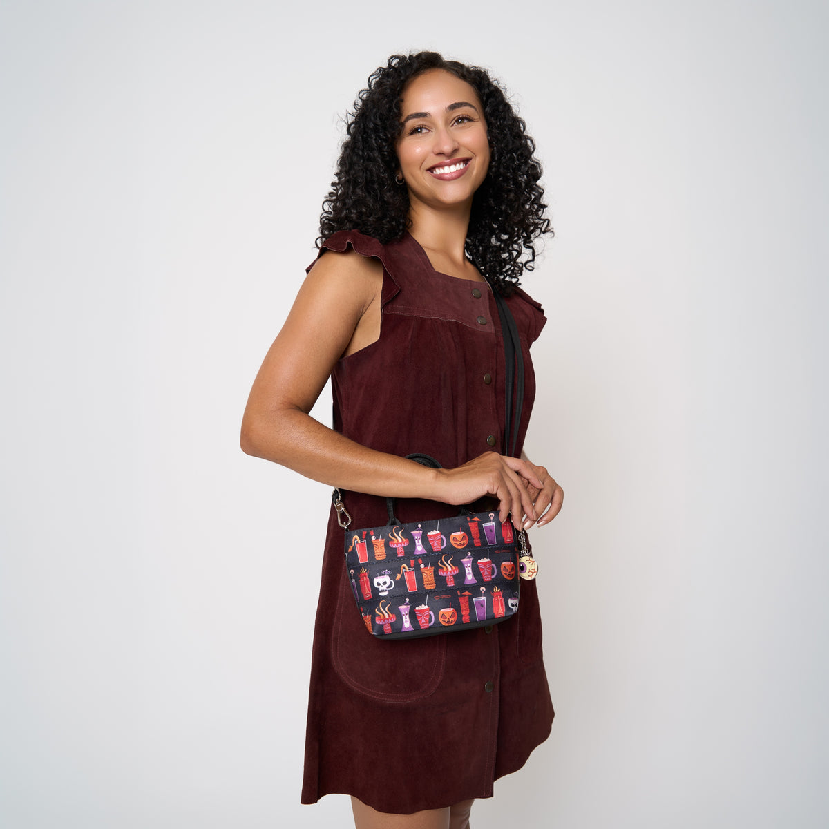 Model wearing petite tote Shag Spooky Tiki Cocktail using extendable shoulder strap.