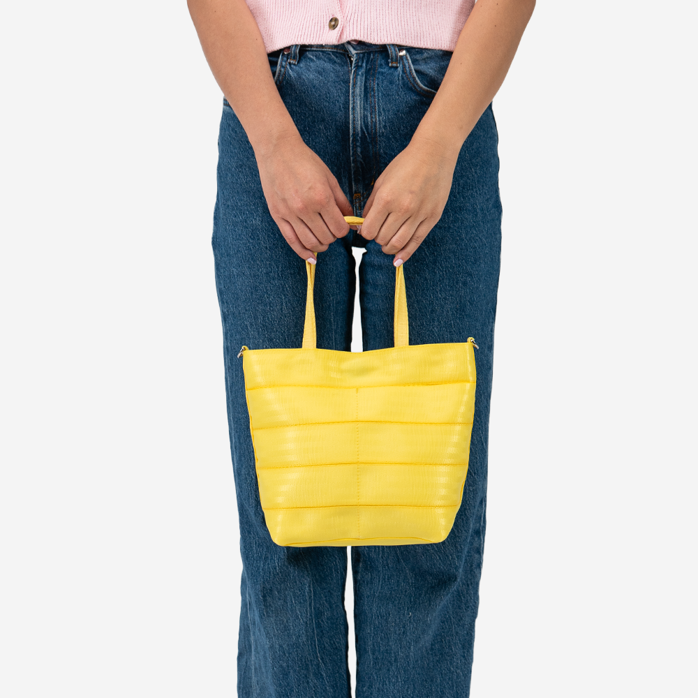 The Rosie Tote in Lemon being held by a model