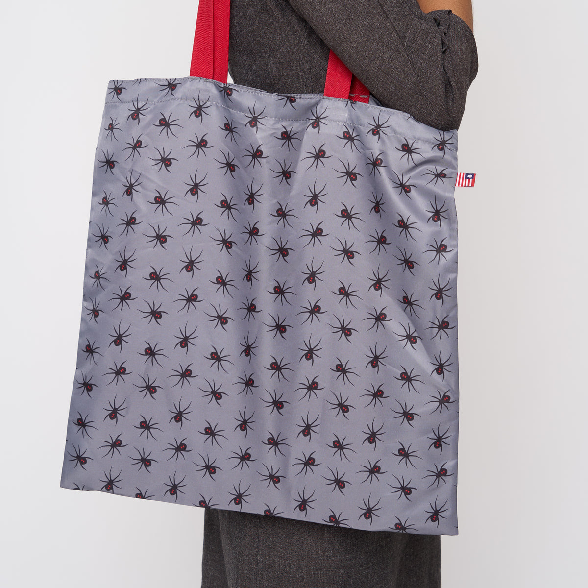 A model wearing a Black Widow Shopper Tote
