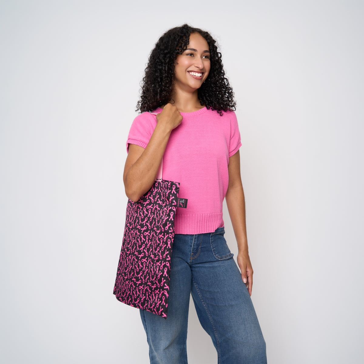 A model wearing The Pink Agenda Pink Ribbon Shopper Tote