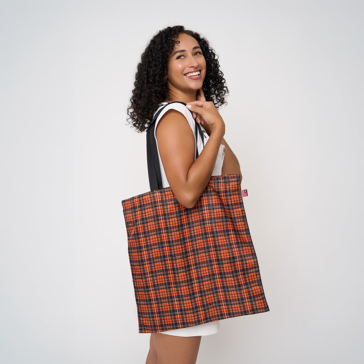 Model carrying shopper tote in Orange Tartan