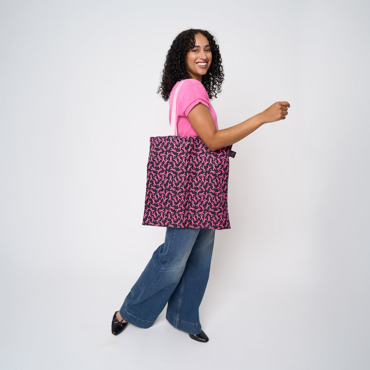 A model wearing The Pink Agenda Pink Ribbon Shopper Tote