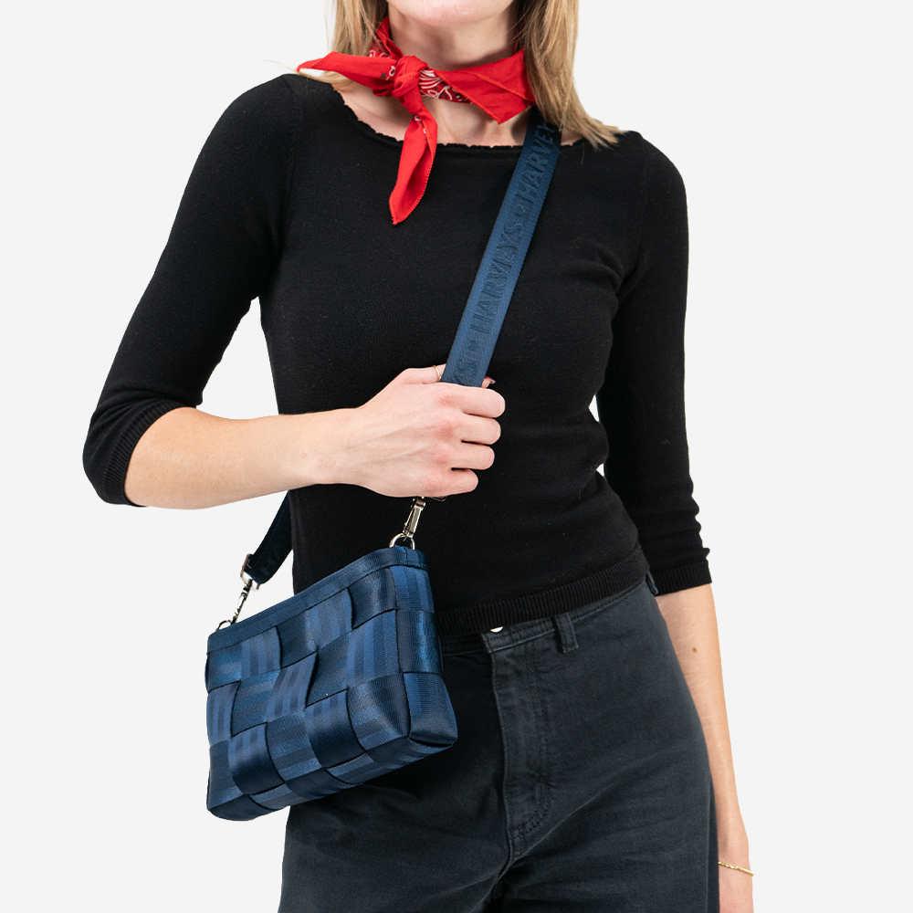 A Convertible Clutch in Indigo being worn by a model