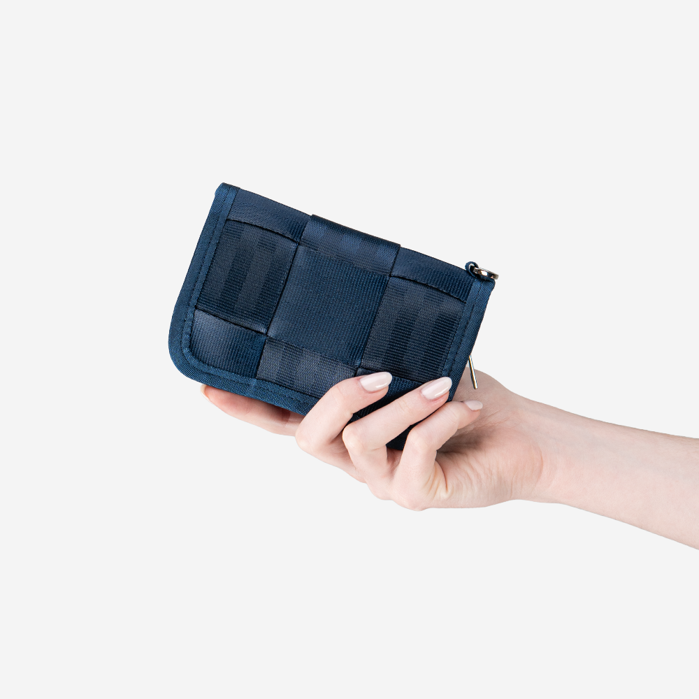 An Indigo Fun Size Wallet in Indigo being held in a models hand