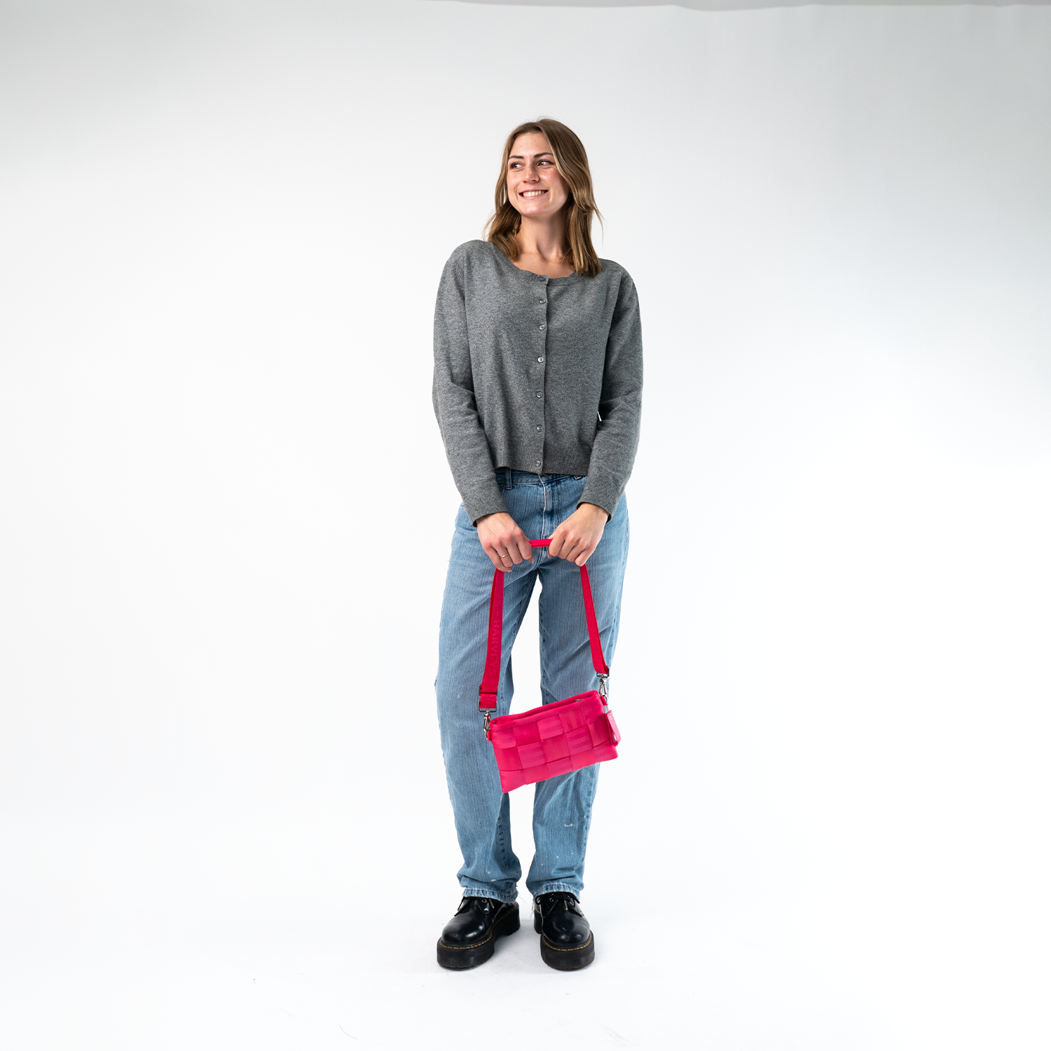 A Hip Pack in Melon being held by a Model