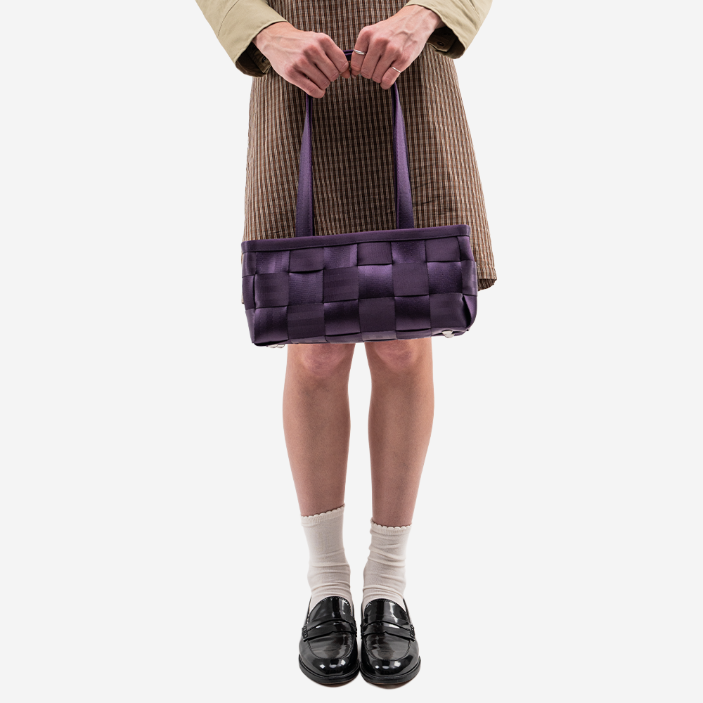 The Satchel in Blackberry being held by a model