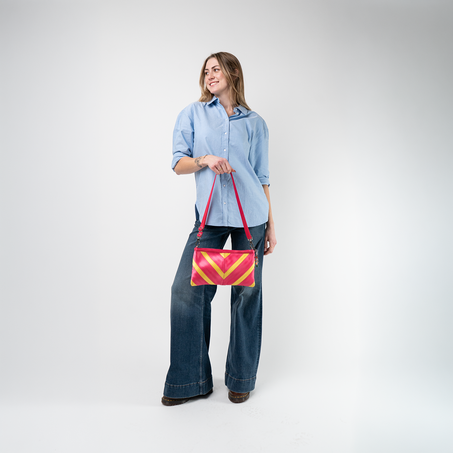 A Strawberry Lemonade Sydney Clutch being used by a model
