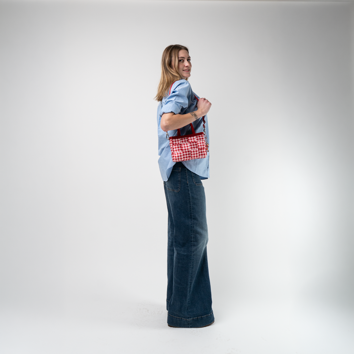 A Red Gingham Woven Petite Tote being used by a model