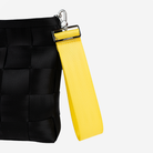 The 5 Panel Keychain in Lemon being used on a bag