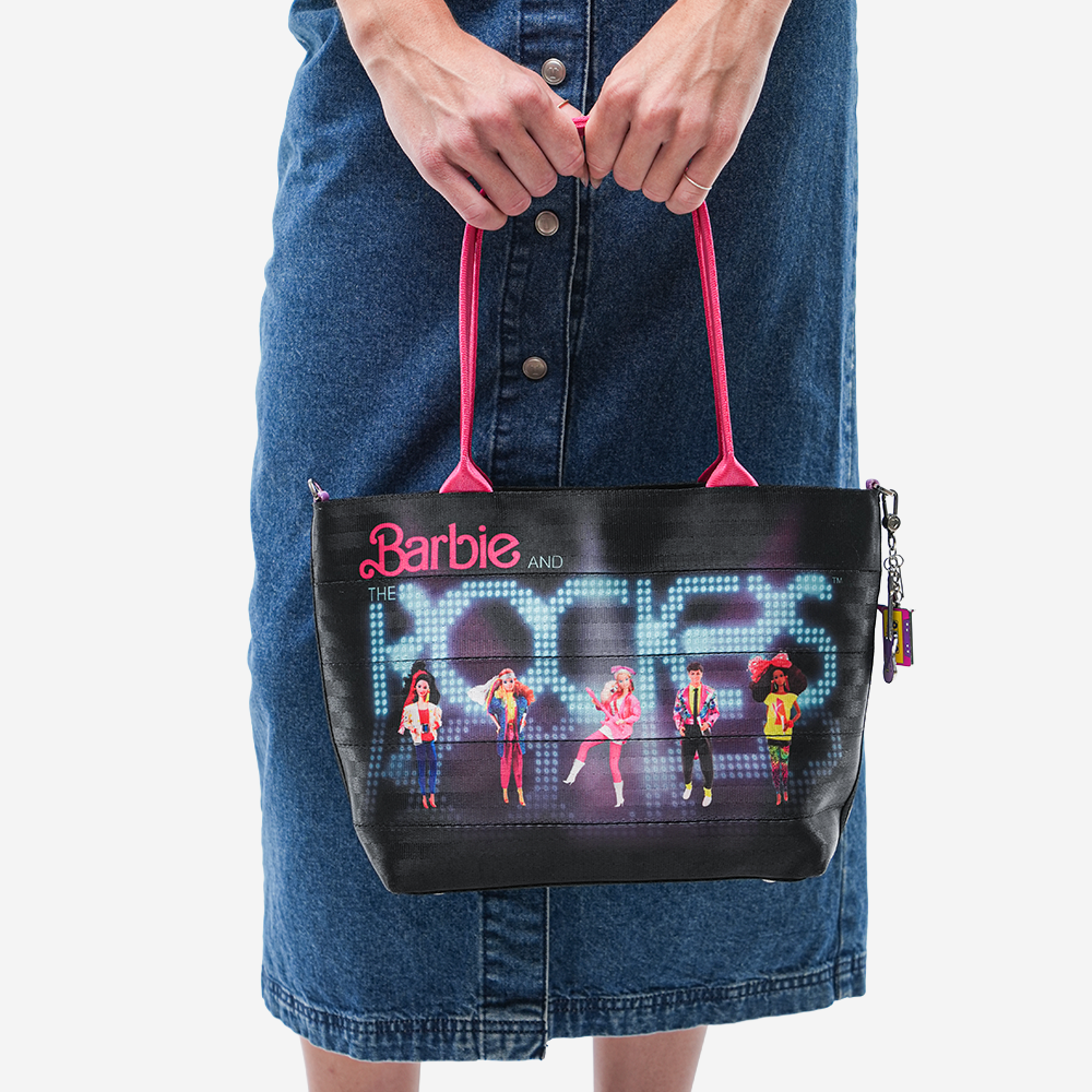 The Barbie And The Rockers Mini Streamline Tote being held by a model