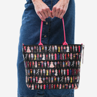 The Barbie Through The Eras Medium Streamline Tote being held by a model