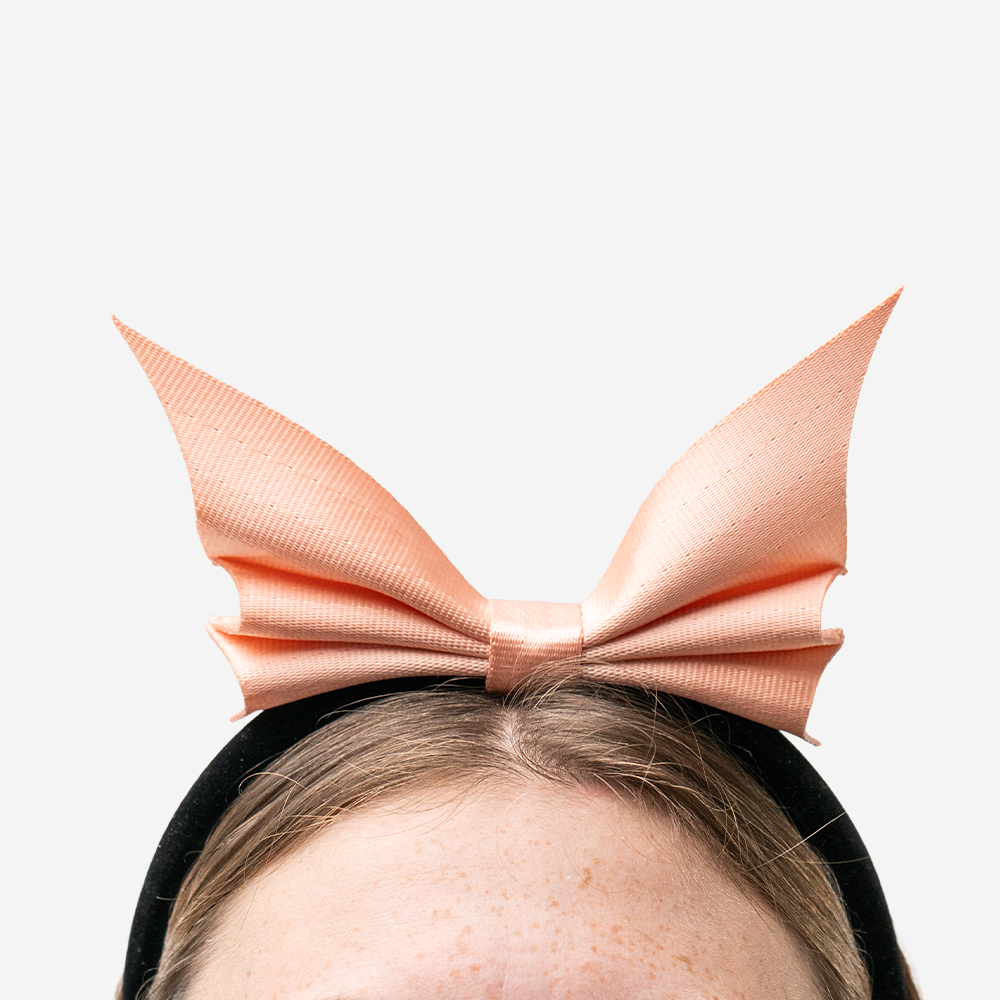 A Bat Headband in Cantaloupe being worn by a model