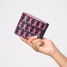 A model holding The Pink Agenda Pink Ribbon Billfold