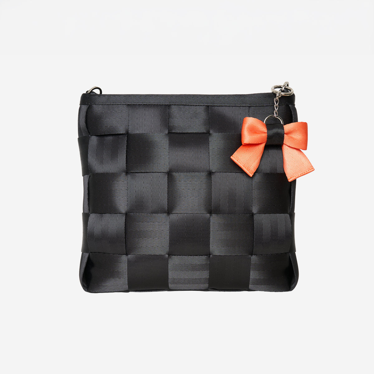 Front view of bow key charm Jack O' Lantern attached to black mini messenger bag