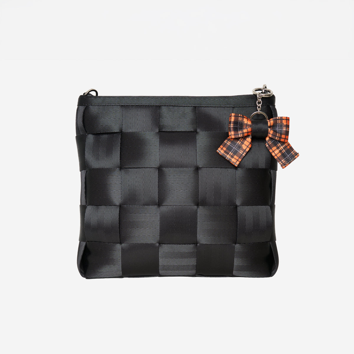 View of Bow Key Charm in Orange Tartan attached to black mini messenger