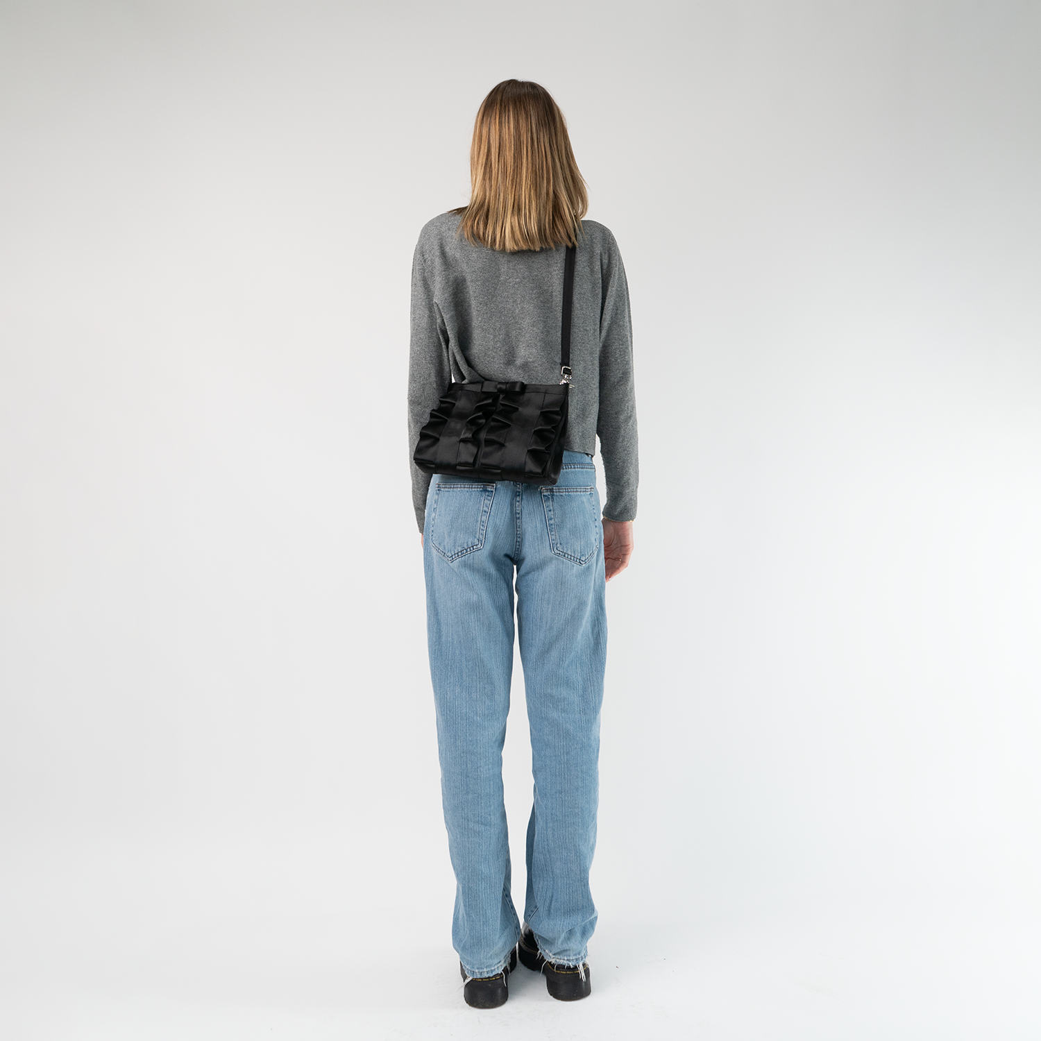 The Black Lola Bow Clutch being worn by a model