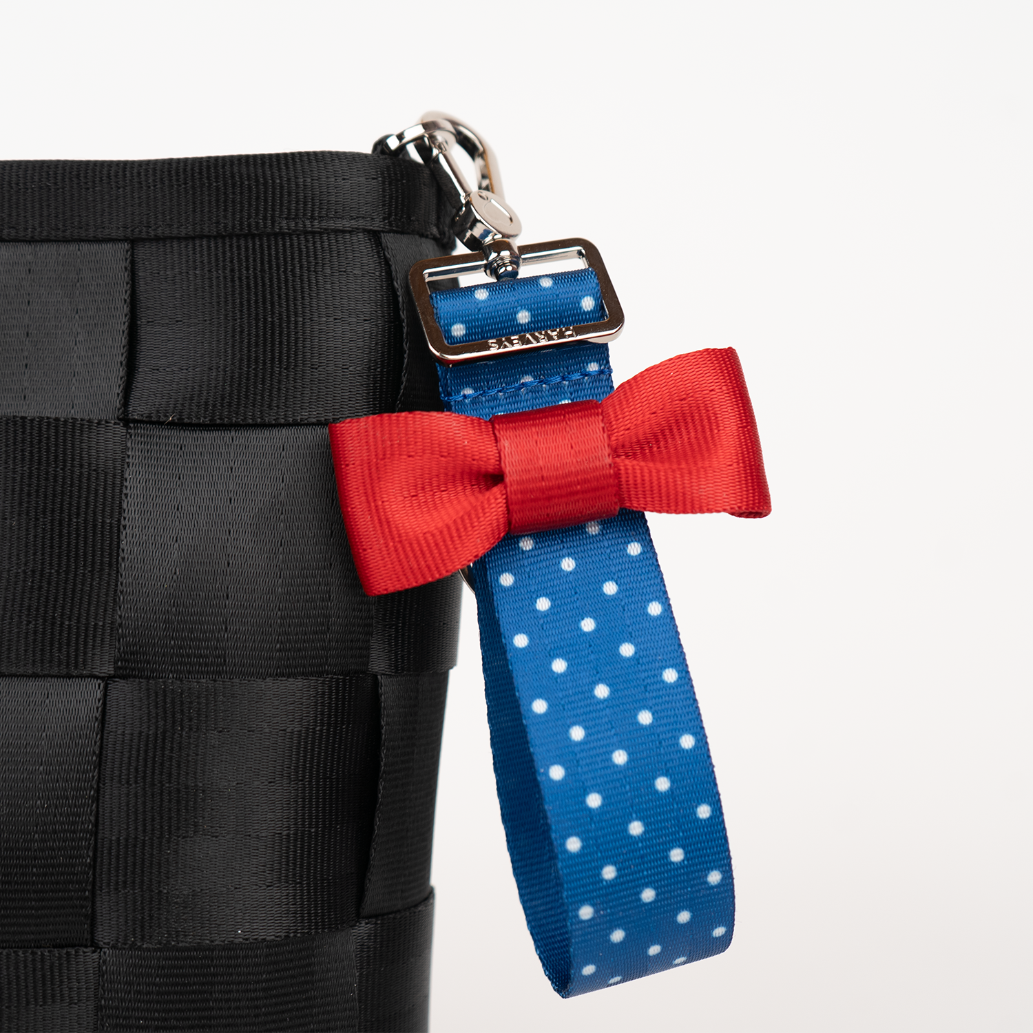 The Scarlet and Blue Dottie Bow Keychain being used on a bag