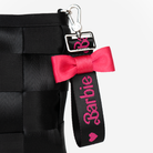 The Barbie Debossed Bow Keychain being used on a bag
