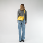 The Buttercup Lola Bow Clutch being worn by a model