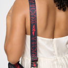 Model wearing black strap with red lettering and red bat design