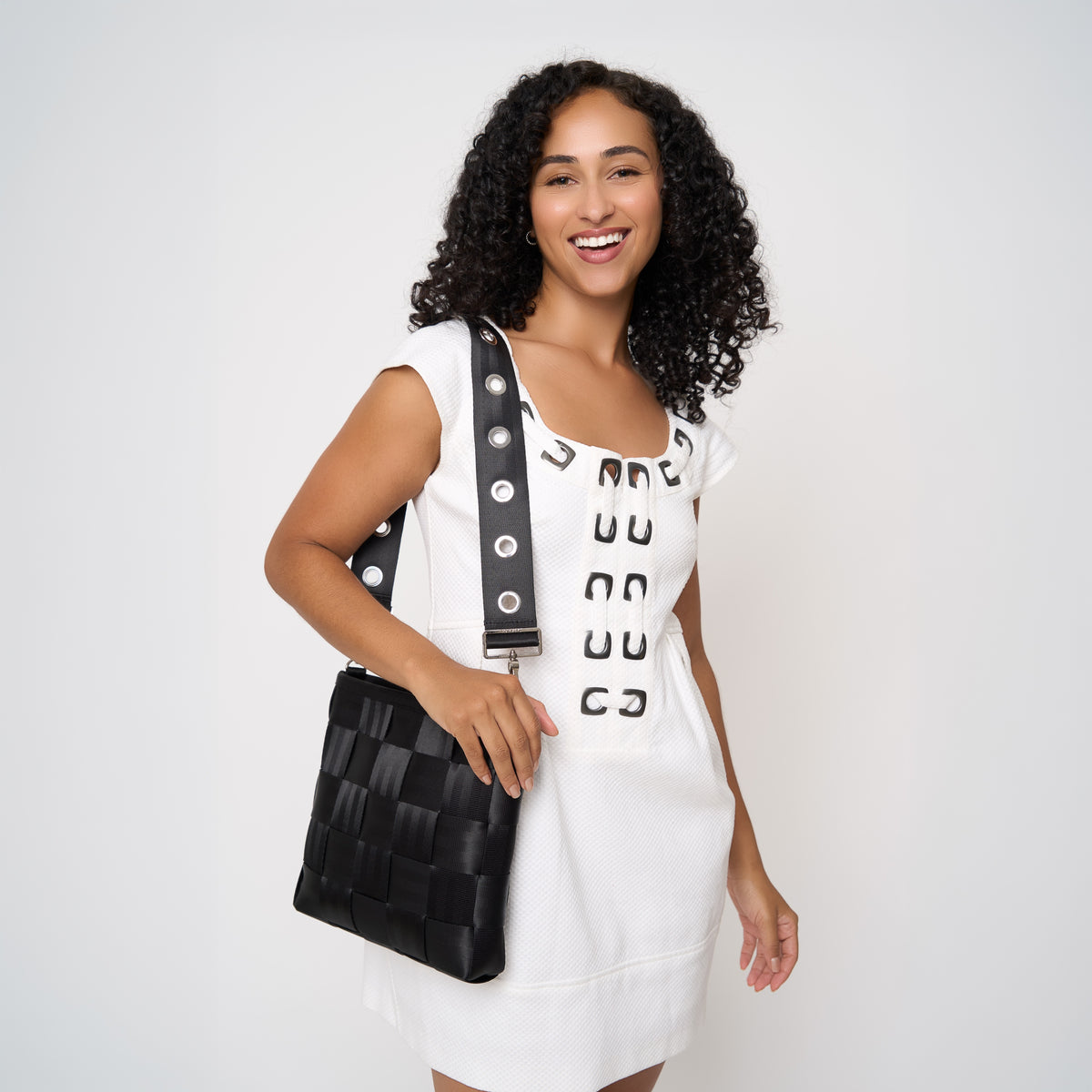 Model wearing 5 panel Click n Carry in grommet attached to black mini messenger