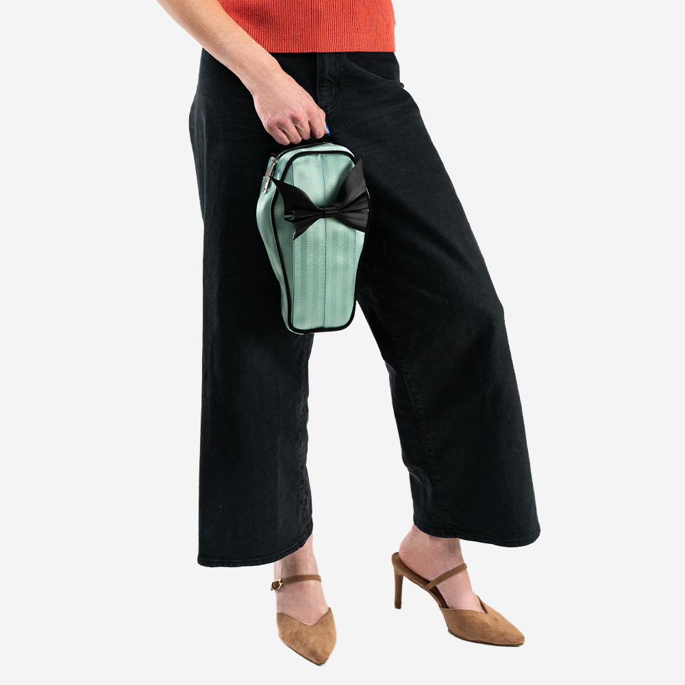 A Mint Coffin Convertible Crossbody being held by a model.