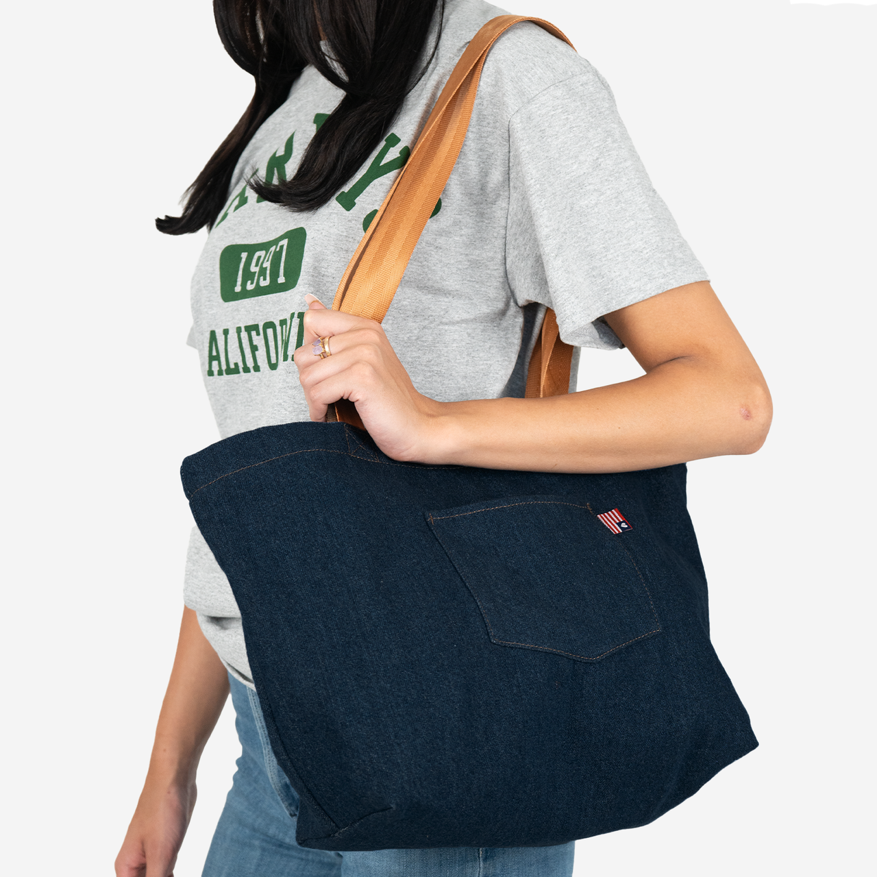 Denim Tote with Cognac handles on a models shoulder
