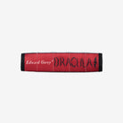 side view of black crossbody book shaped  bag displaying red book spine