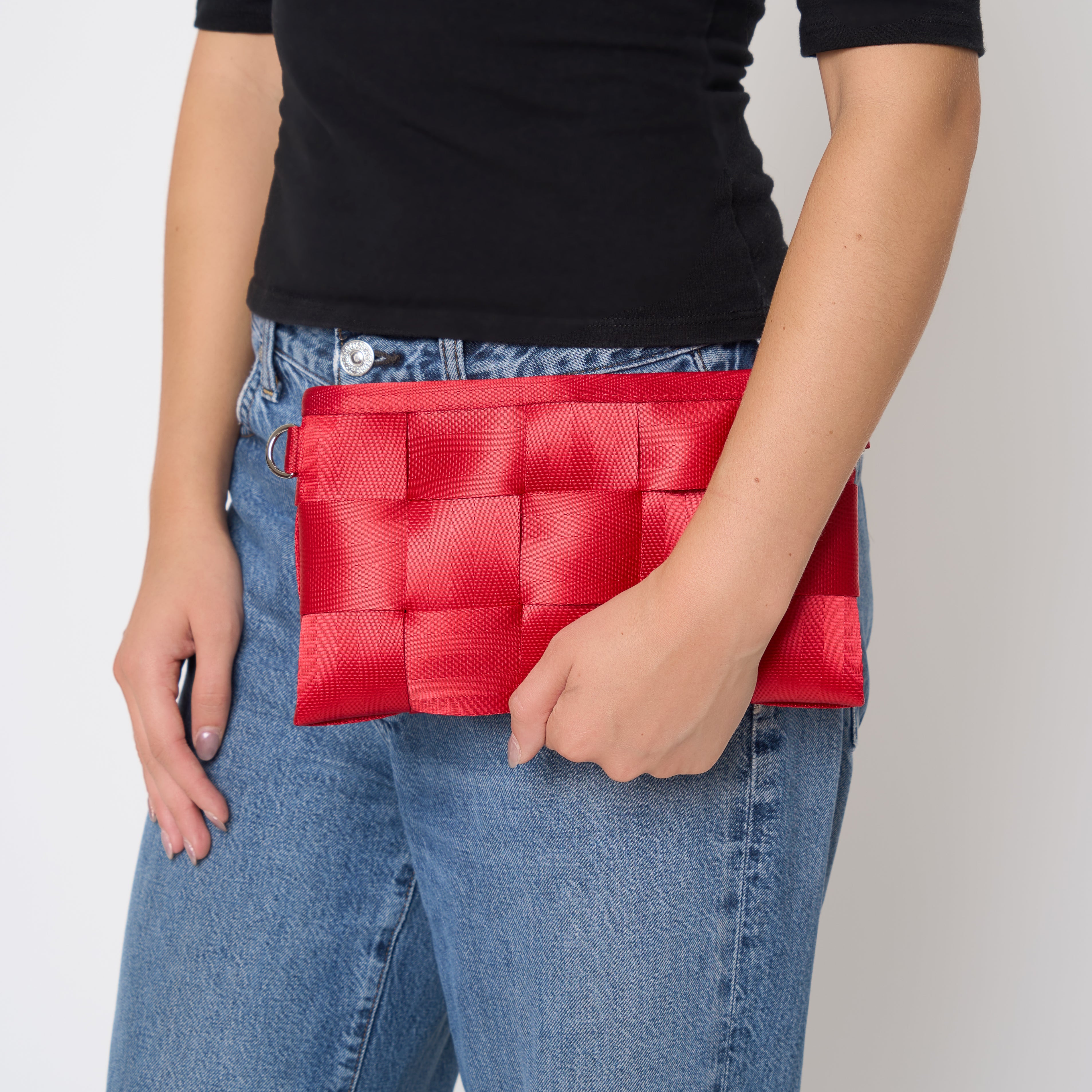 Hip Pack Scarlet with straps detached being used by model as a clutch