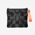 Front view of keychain orange attached to black mini messenger bag