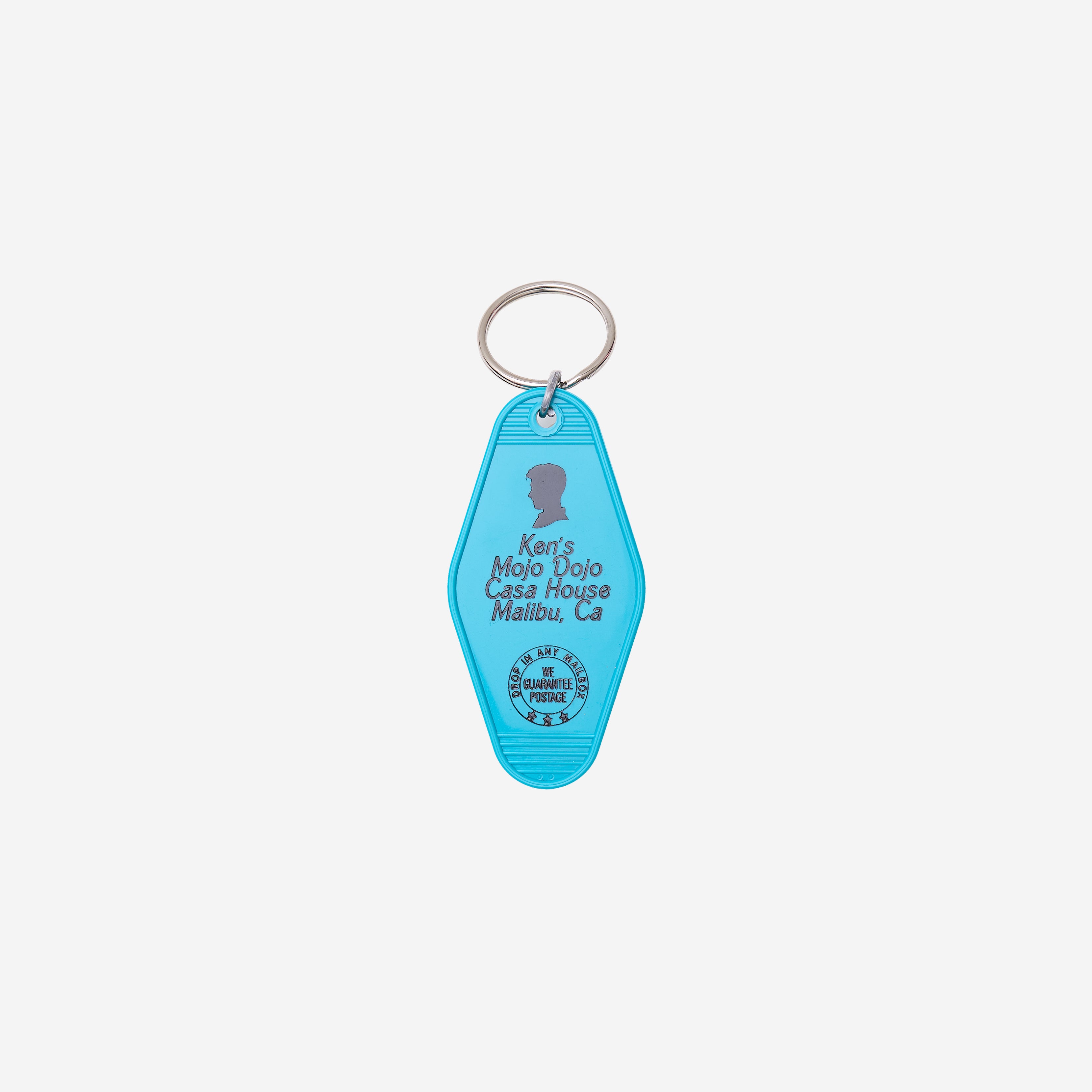 A bright turquoise blue Key tag featuring a silver split ring. The Key tag is printed with  'Ken's Mojo Dojo Casa House Malibu, Ca.