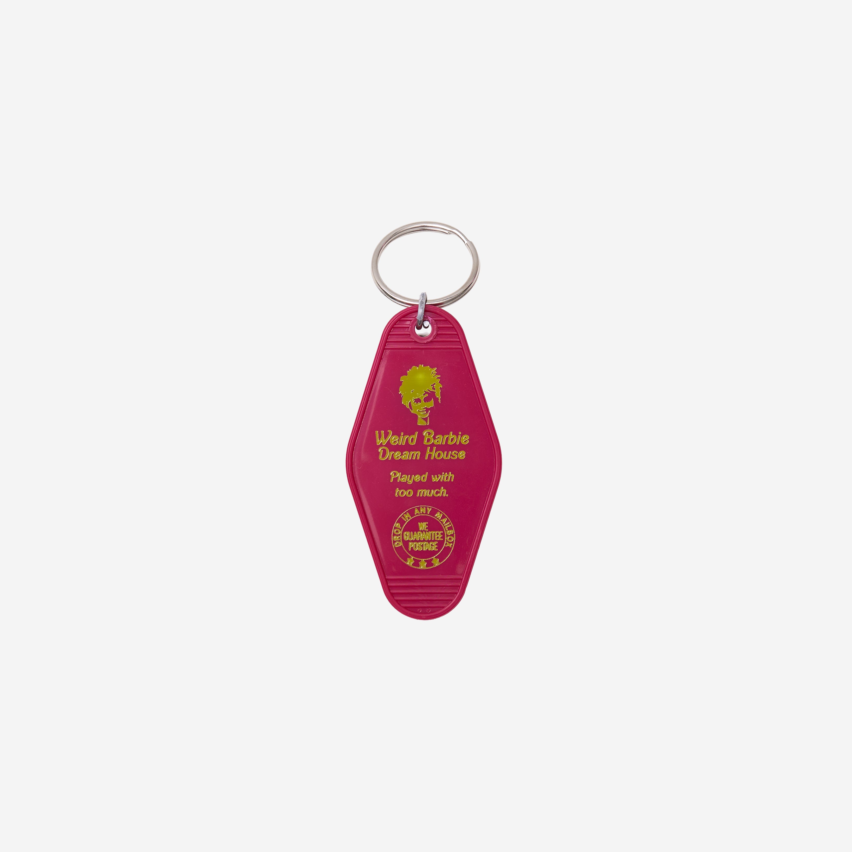 A magenta plastic Key Tag featuring gold foil text that reads 'Ward Barbie Dream House' and 'Played with too much,' attached to a silver metal key ring against a light gray background.