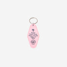 A pink key tag featuring the Barbie Dream House address printed in black, attached to a silver metal split ring, on a light gray background.