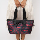 Model holding large bat tote with red Dracula lettering