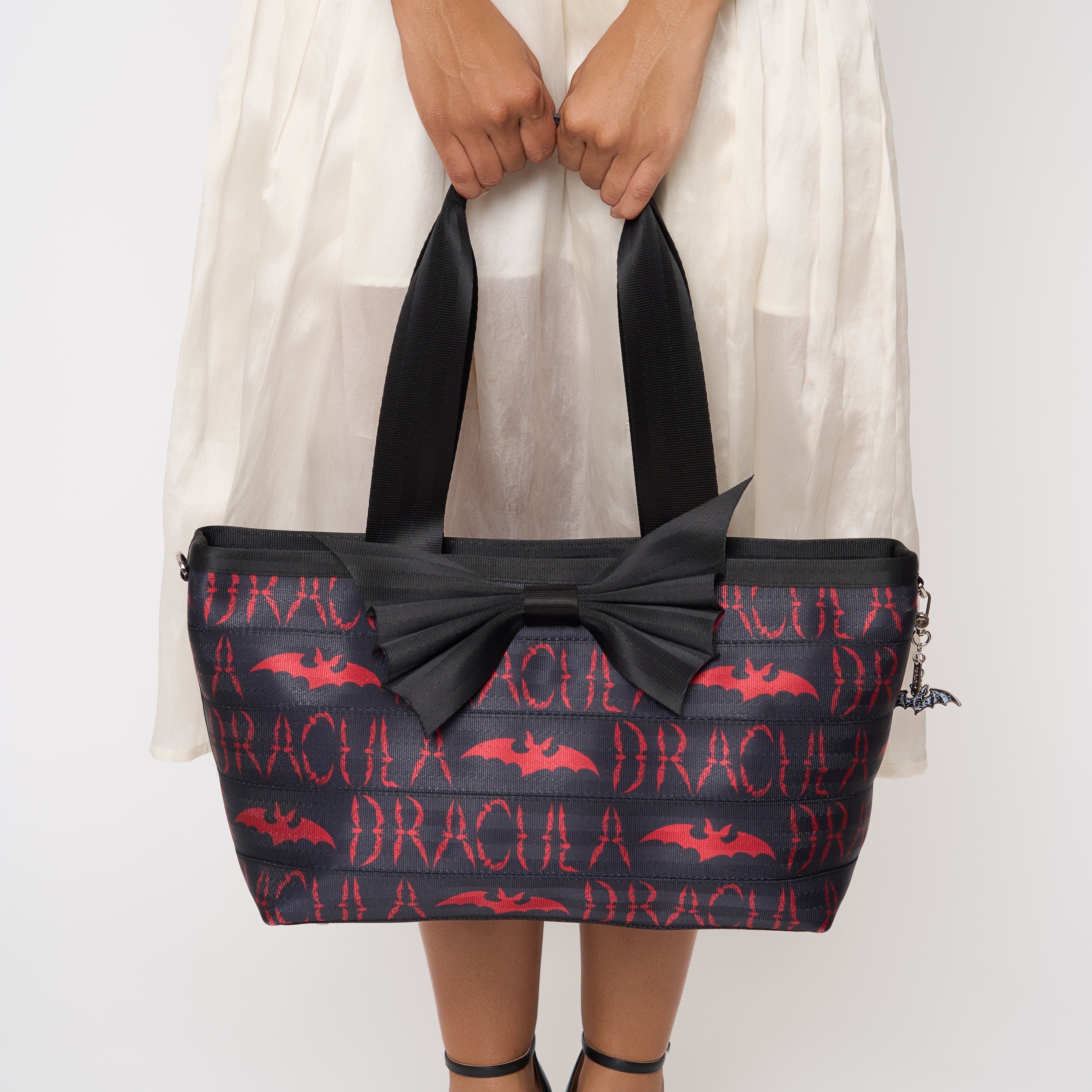 Model holding large bat tote with red Dracula lettering