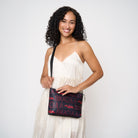 Model wearing black clutch using adjustable black strap 