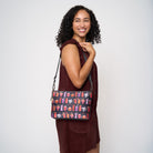 Model using extendible shoulder strap to wear Medium Convertible Clutch Shag Spooky Tiki Cocktail