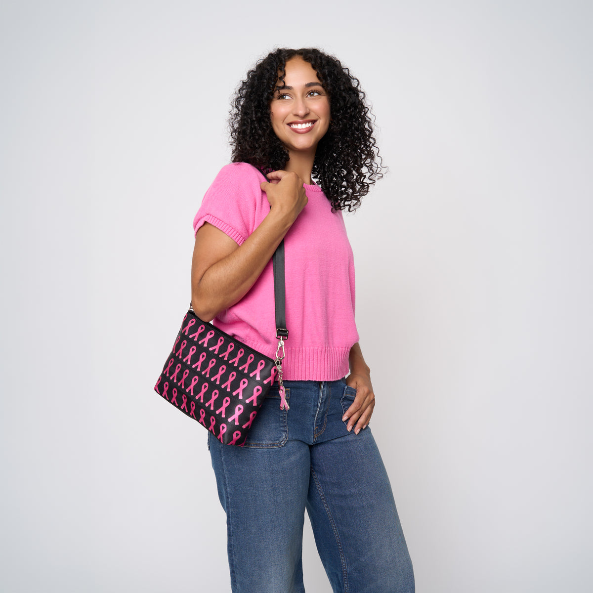 A model wearing The Pink Agenda Pink Ribbon Medium Convertible Clutch